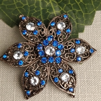 brunt metal med blå og klare simili stene blomsterstjerne vedhæng. gammelt smykke.
